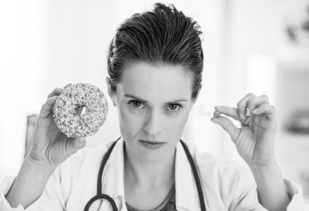 严肃的医学的医生女人展映油炸圈饼和药丸