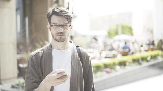 一年幼的严肃的男人手指已提到的人蜂窝式便携无线电话眼睛在指已提到的人照相机