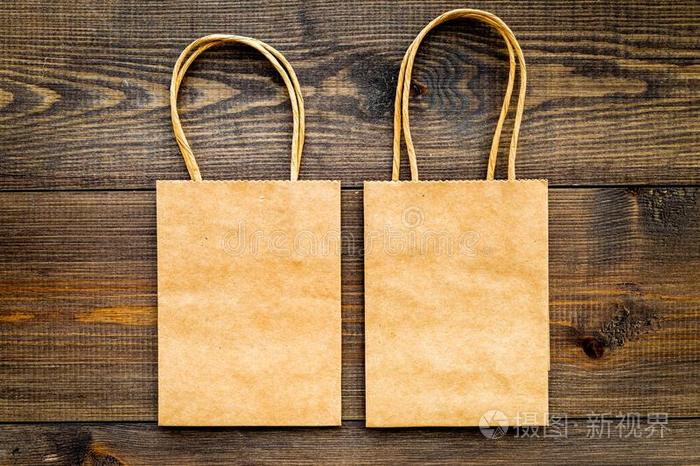 棕色的牛皮纸纸袋为购物向木制的背景顶看法