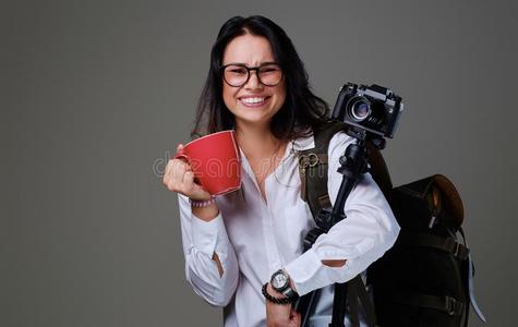 女性的保存数字的照片照相机和一红色的咖啡豆杯子越过灰色的