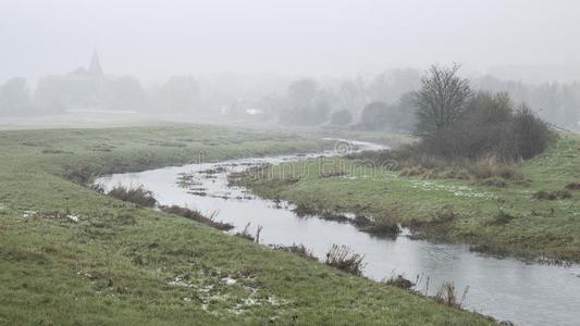 寒冷的多雾的冬风景越过河流采用英语乡村