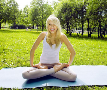 白肤金发碧眼女人真的女孩做瑜伽采用绿色的公园,生活方式真的人