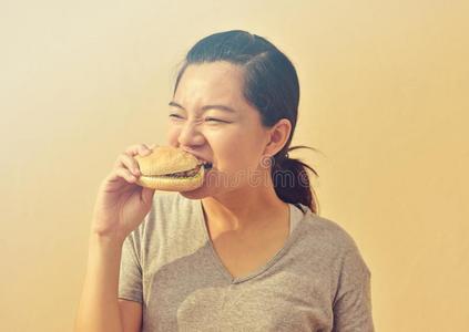 年幼的女人吃废旧物品食物汉堡包采用手