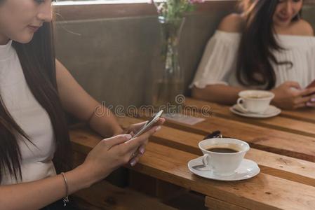 两个十几岁的女人相遇采用咖啡豆商店使用智能手机比赛社会的