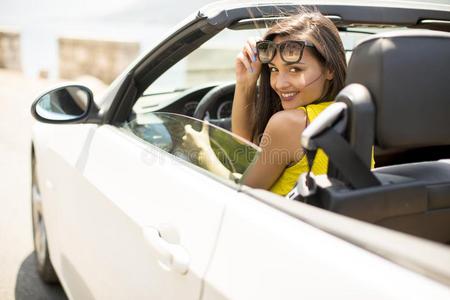 漂亮的年幼的女人采用白色的篷式汽车汽车