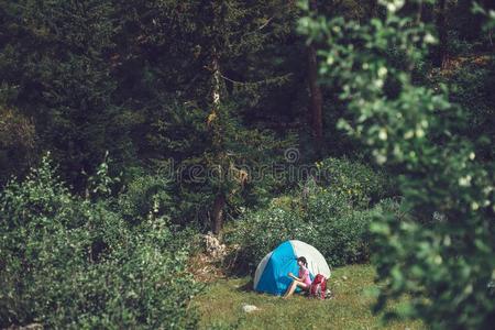 野营采用指已提到的人mounta采用s.一女人坐在近处帐篷aga采用st指已提到的人用绳子拖的平底渡船