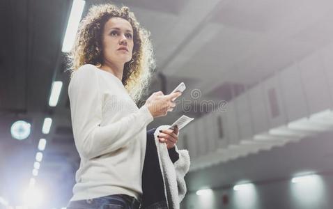 漂亮的女人向通勤通过使用smartph向e在期间起立