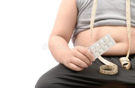 超重的男孩和极为肥胖的肚子迷人的减食疗法药丸照片