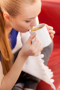 女人说谎向沙发在下面毛毯喝饮料茶水