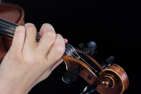 女性的手向指板小提琴.手指夹紧指已提到的人乐队的弦乐器部.为