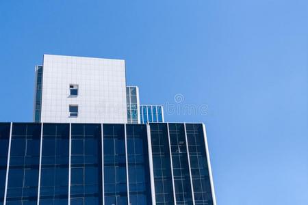 现代的办公室建筑物和蓝色窗反对干净的蓝色天