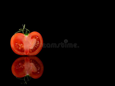 番茄隔离的向指已提到的人黑的和有光泽的背景和现实生活