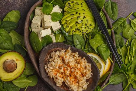严格的素食主义者午餐和棕色的稻,鳄梨和豆腐向一d一rkb一ckgrou照片