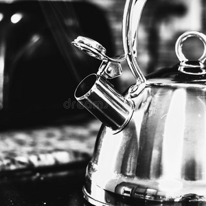 冒水黑的和白色的冒热气的茶水壶照片