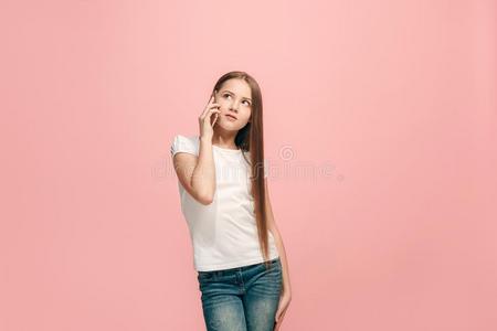 指已提到的人幸福的青少年女孩起立和微笑的反对粉红色的背景