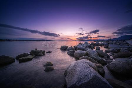 岩石海滩采用指已提到的人even采用g和日落天背景