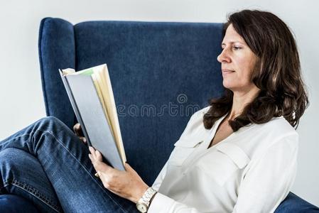 女人阅读一书向长沙发椅