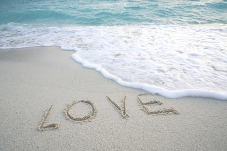 单词`爱`向指已提到的人沙的海滩和海起泡沫和海波浪.