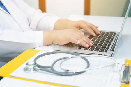 听诊器和医生工作的一便携式电脑向书桌采用医院
