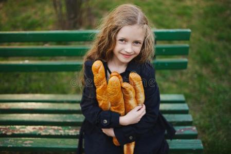年幼的美丽的女孩和法国长面包