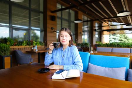 高加索人女性的人一次在咖啡馆和智能手机和笔记