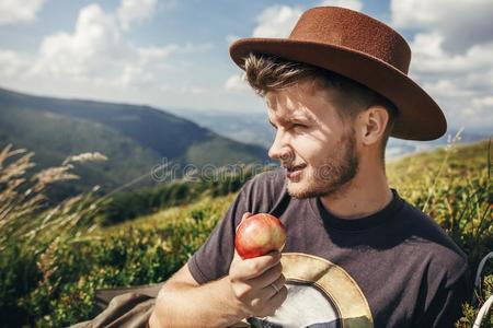时髦的旅行支票男人采用帽子eat采用g苹果向顶关于和煦的：照到阳光的莫泰