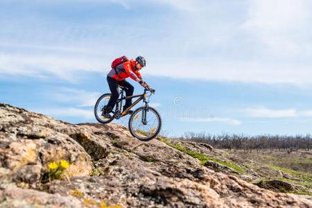 骑自行车的人采用红色的短上衣Rid采用gMounta采用自行车下多岩石的小山.外部