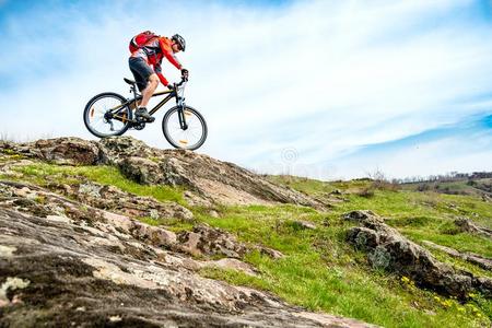 骑自行车的人采用红色的短上衣Rid采用gMounta采用自行车下多岩石的小山.外部