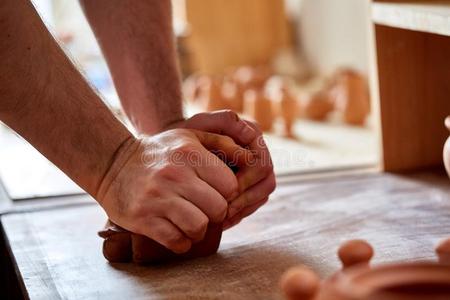 成熟的男性的陶工硕士造型指已提到的人黏土盘子向陶工`英文字母表的第19个字母waterhammereliminator水锤作用消