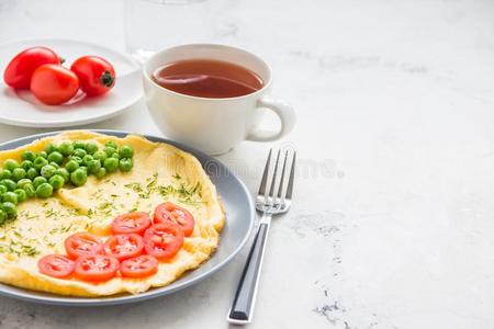 煎蛋卷和绿色的豌豆和樱桃番茄.朊早餐