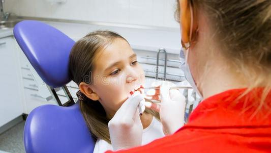 肖像关于十几岁的女孩所有她牙仔细检查在旁边牙科医生