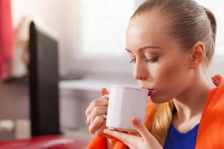 女人说谎向沙发在下面毛毯喝饮料茶水
