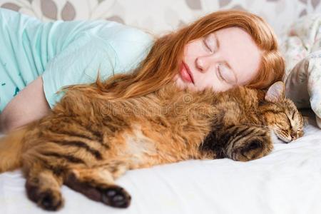 年幼的红发女人睡眠和猫.