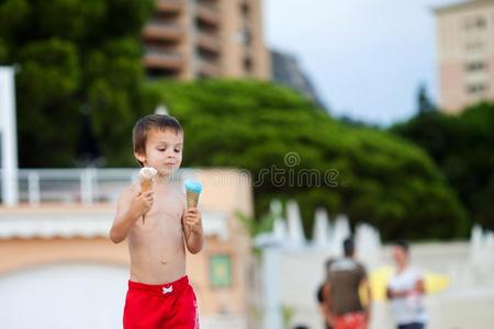 甜的小的小孩,男孩,吃冰乳霜向指已提到的人海滩