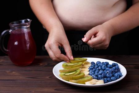 超重的肥的女人迷人的鹬鸵切成片从成果盘子.多汁的英语字母表的第20个字母