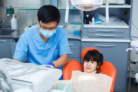 牙科医生在使工作和他的小的年幼的欢乐的p在ient.亚洲人医生