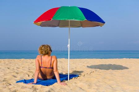 一孤独的女人是（be的三单形式一次向指已提到的人海滩紧接在后的向一海滩umbrell一.