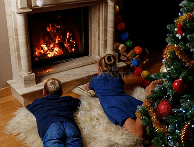 小孩说谎向暖和的毛毯和有样子的采用向指已提到的人壁炉.