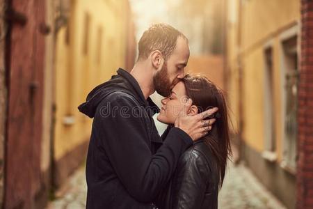 有胡须的男人和黑头发的妇女女孩接吻的,向指已提到的人背景关于指已提到的人