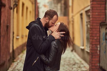 有胡须的男人和黑头发的妇女女孩接吻的,向指已提到的人背景关于指已提到的人