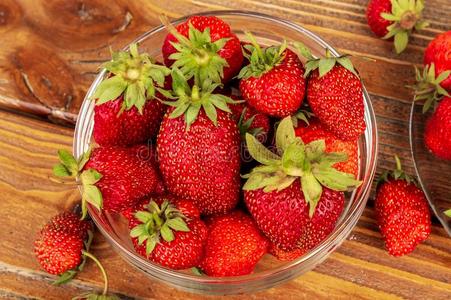 成熟的红色的有机的草莓采用一gl一ss碗一g一采用st棕色的木材