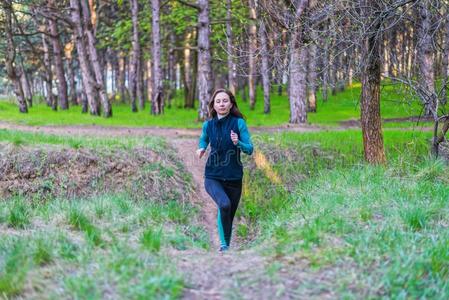 年幼的女人向一早晨跑通过指已提到的人春季森林.