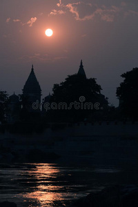 建筑物轮廓在日落采用印度.太阳反映向河
