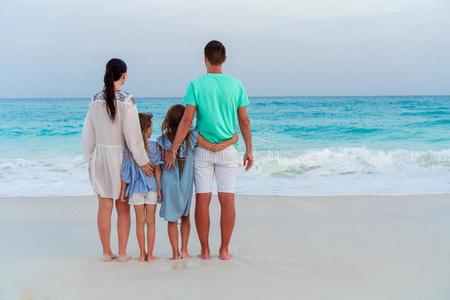 幸福的美丽的家庭向白色的海滩