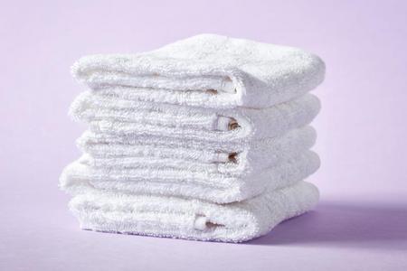 白色的休闲健身中心毛巾向紫色的背景