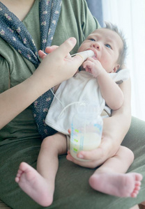 手指给食乳房奶向新生的婴儿男孩使用小的管