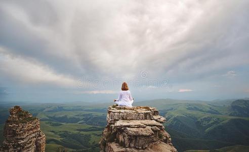 女人练习瑜伽和深思向山