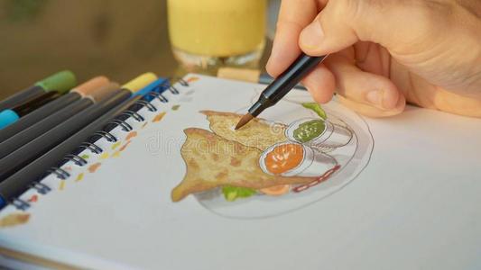 男性的设计师绘画食物草图,关-在上面.