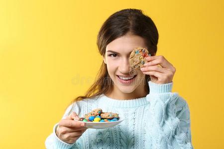 漂亮的年幼的女人吃美味的饼干