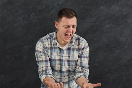 表现强烈情感的强调男人肖像向黑暗的背景